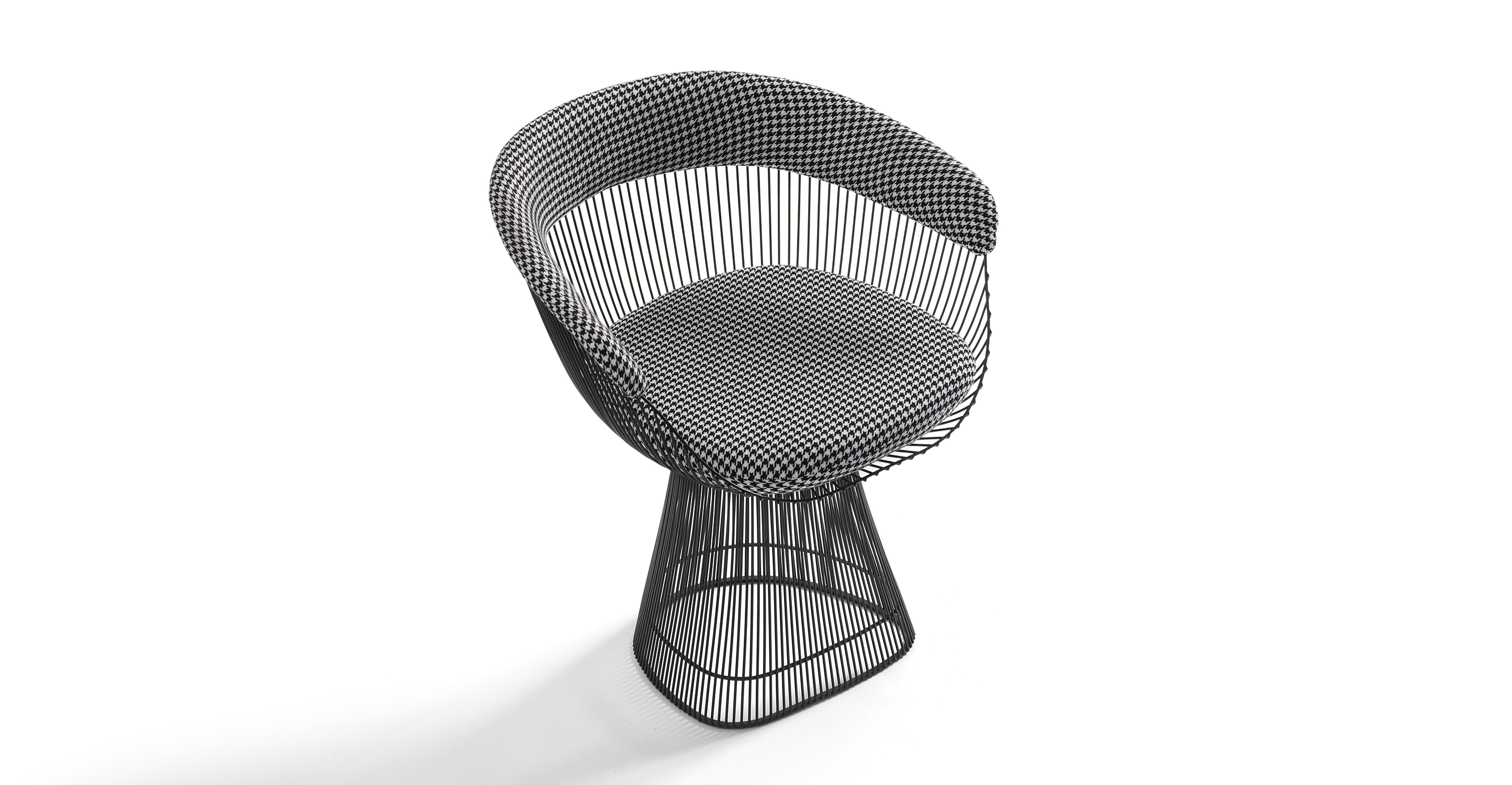 The Platner dining chairs have a wide base that tapers up and meets a bucket seat also made of black stainless steel rods. The arms and black are cushioned with upholstery and the seat has a removable cushion. 